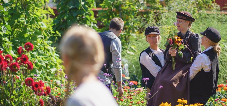 Teaterelever på Herminas lott en trädgård med många blommor